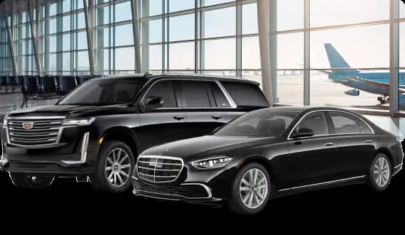 Black SUV and sedan parked at an airport terminal