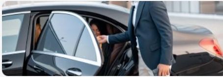 Chauffeur opening a car door at the curb